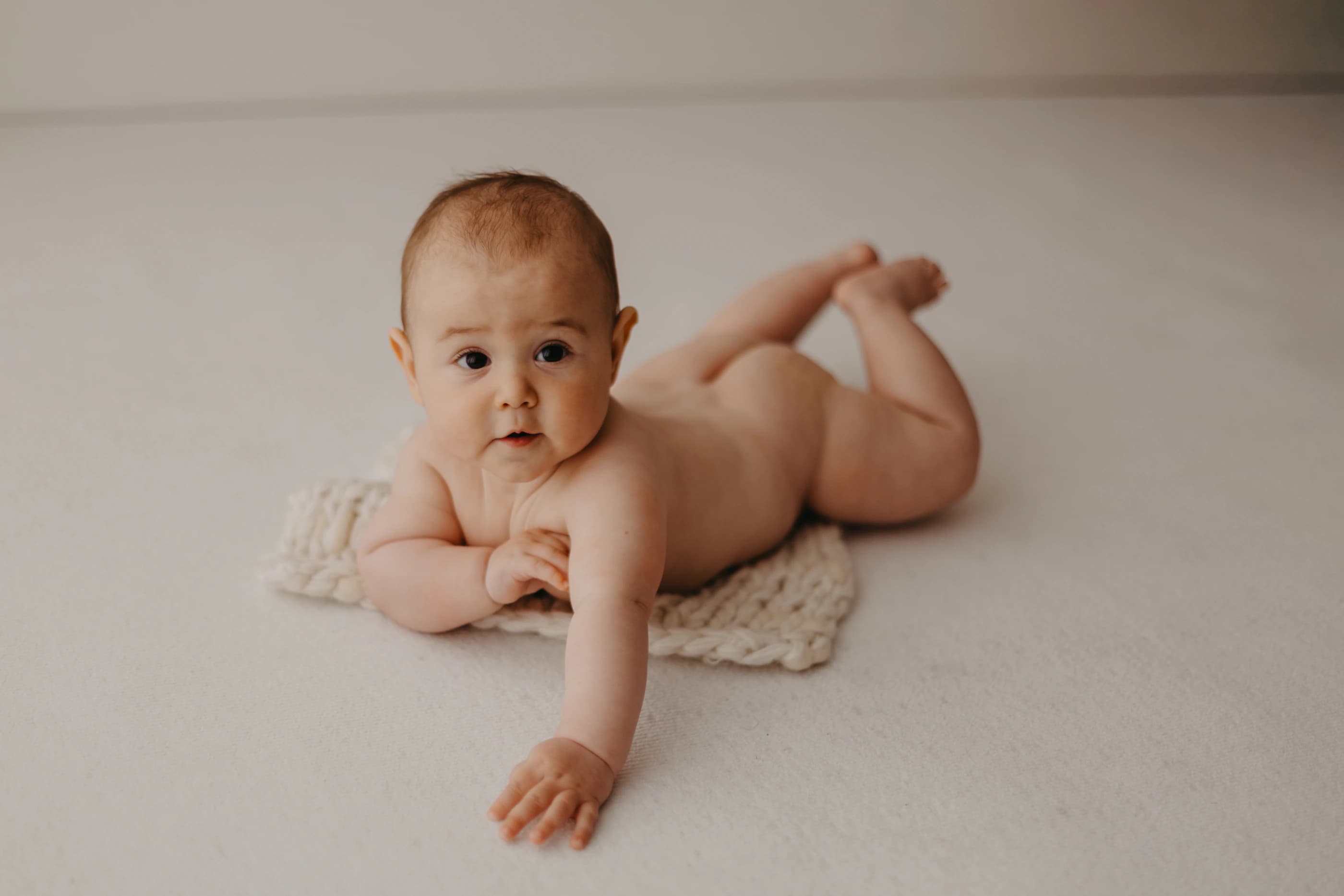 Bambino disteso a pancia in giù mentre esplora lo spazio