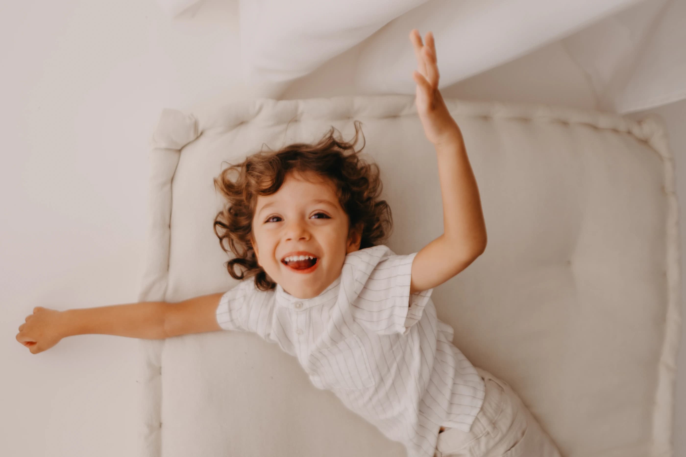 Bambino in movimento con le braccia aperte e il viso sorridente