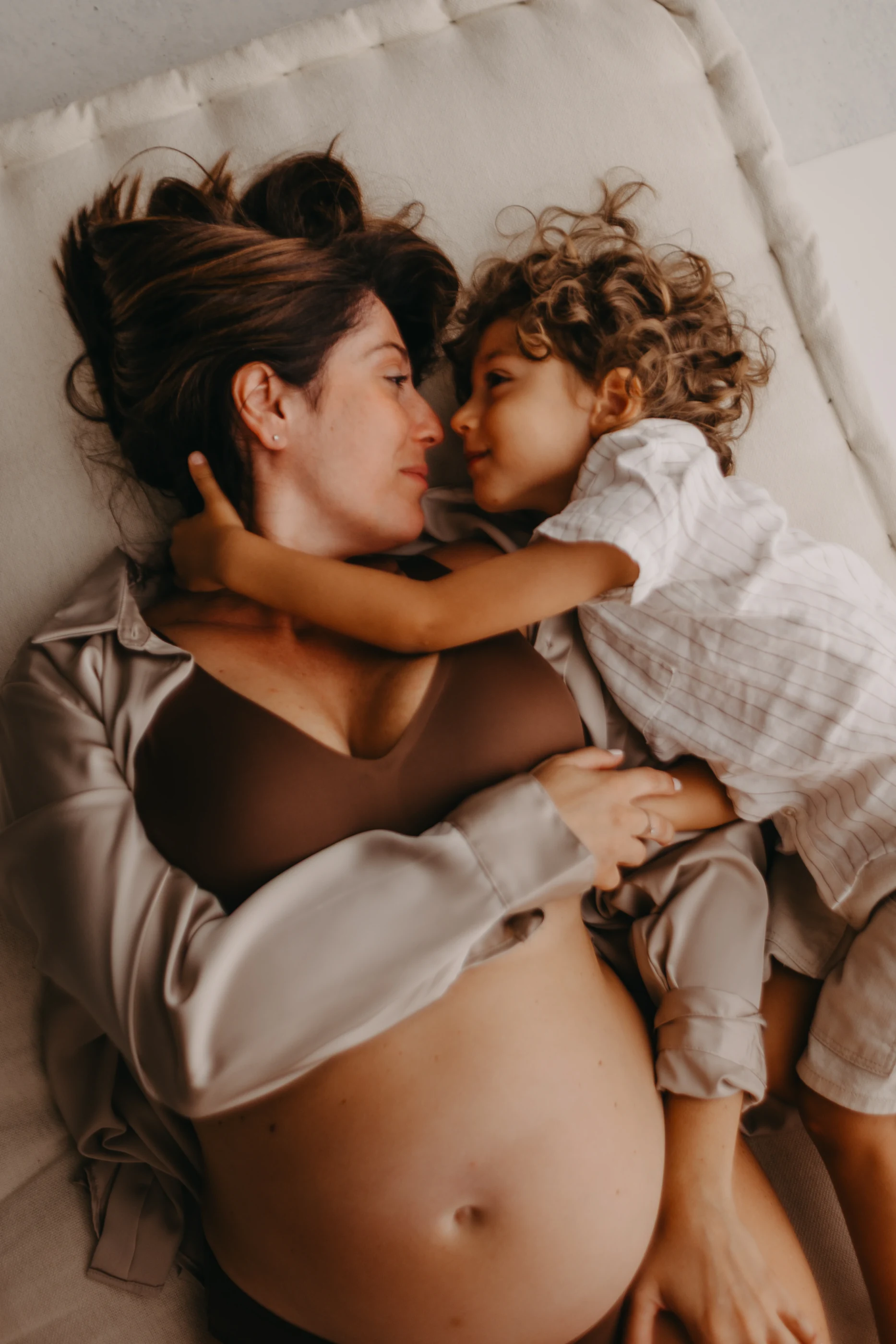 Madre in gravidanza e figlio si guardano abbracciati