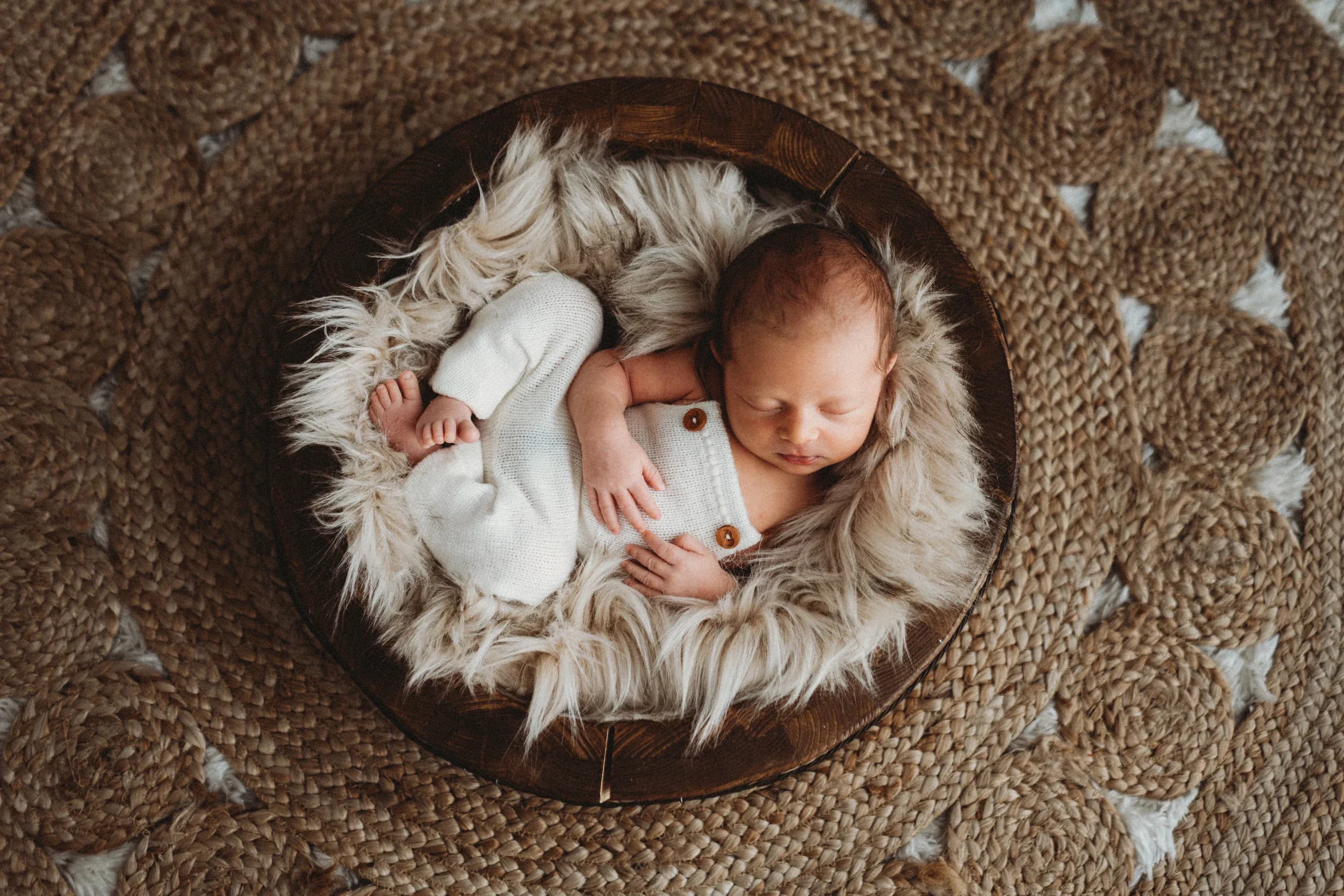Neonato addormentato in un nido di tessuti naturali