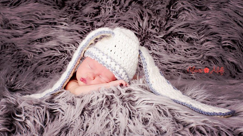 newborn con cappello di maglia bianco