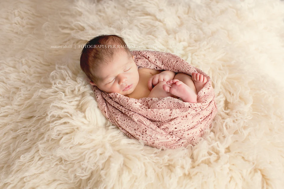 fotografo neonati cuneo Neonata addormentata in una coperta rosa su un telo bianco