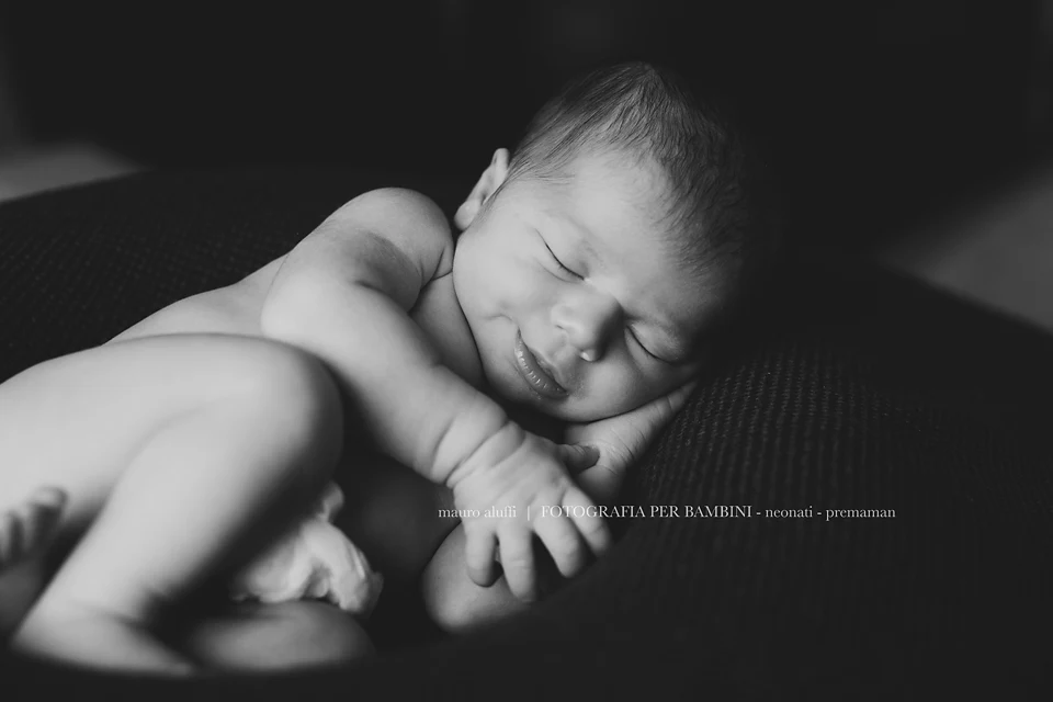 fotografo neonati cuneo Neonata addormentata con le mani raccolte sotto il viso