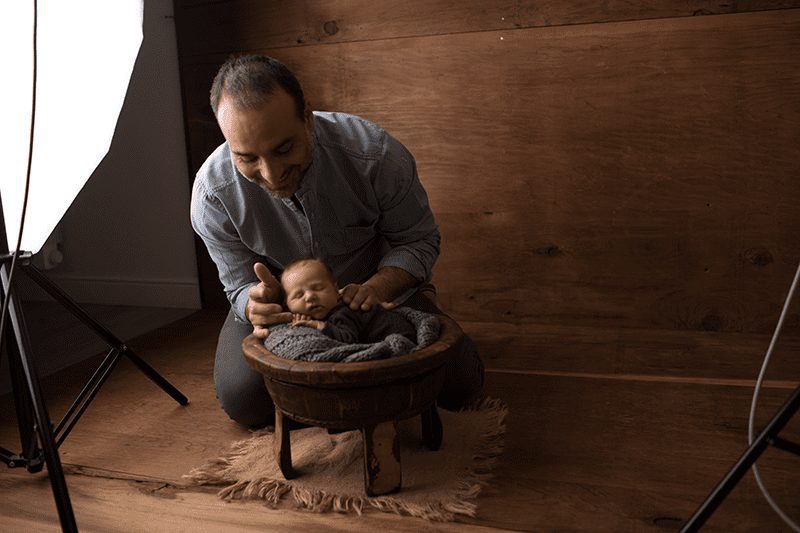 Mauro Aluffi sistema un neonato nel set fotografico