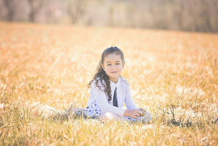Bambina distesa nell’erba dorata