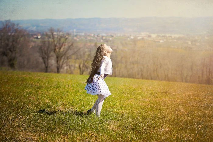 Bambina osserva il paesaggio da una collina