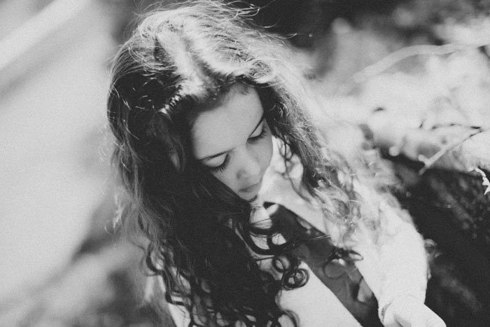 Primo piano in bianco e nero di una bambina con lunghi capelli ricci
